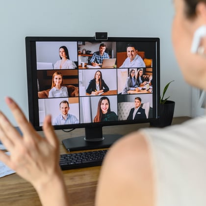 A woman talking with coworkers over video chat