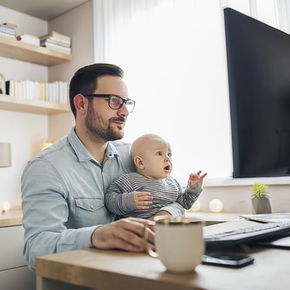 AdobeStock image of man working from home with baby