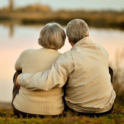 Senior couple sitting by a lake