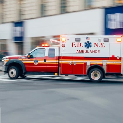 FDNY Ambulance flashing lights siren blasting speed through midtown rush hour traffic in Manhattan.