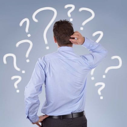 Shutterstock image of the back of a man wearing a business shirt and pants standing up and surrounded by 10 question marks
