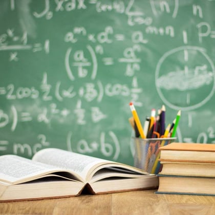 A teacher's desk in front of a blackboard. (Image: Shutterstock)