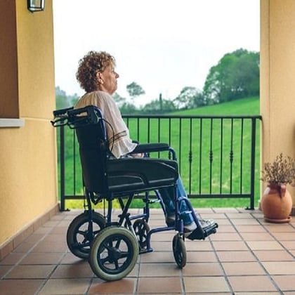 A woman in a wheelchair, on a condo patio. (Image: Shutterstock)