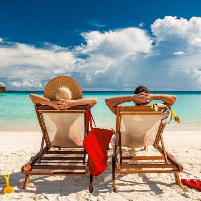 Young couple relaxing on the beach in chairs