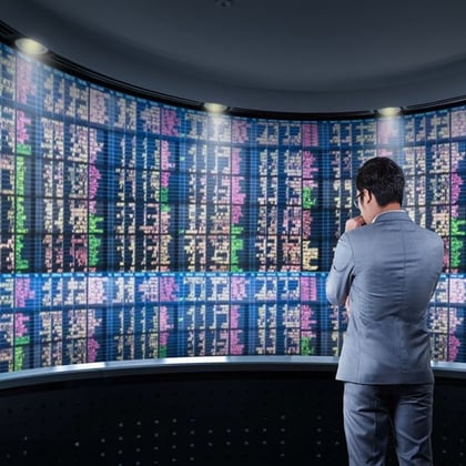 A businessman looking at a stock board