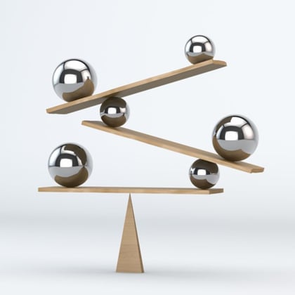 Balls and boards balanced on a fulcrum illustrating a balance of assets and liabilities