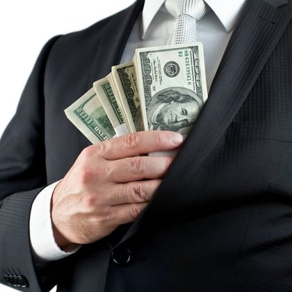 A man putting money in suit jacket pocket