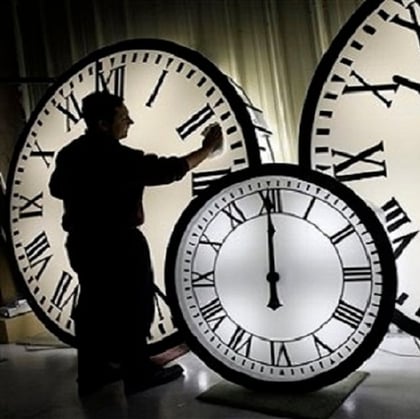 A clock caretaker polishing shadowy old clock faces. (Image: Elise Amendola/AP)