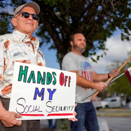 A demonstrator holds a sign that says 