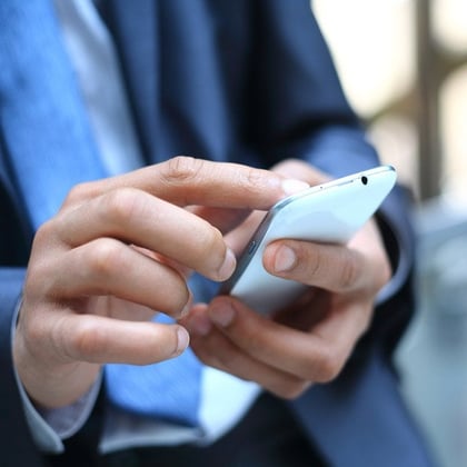 A businessman sending messages on a smartphone