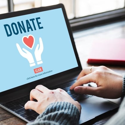 person with a laptop donating to a charity