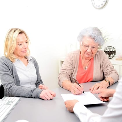 A senior woman signing a contract