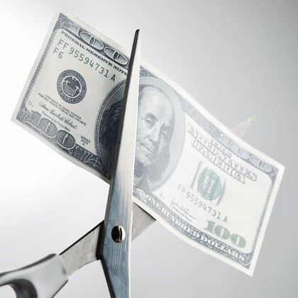 Scissors cutting money