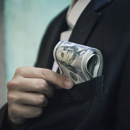 Rich person with $100 bills in suit pocket