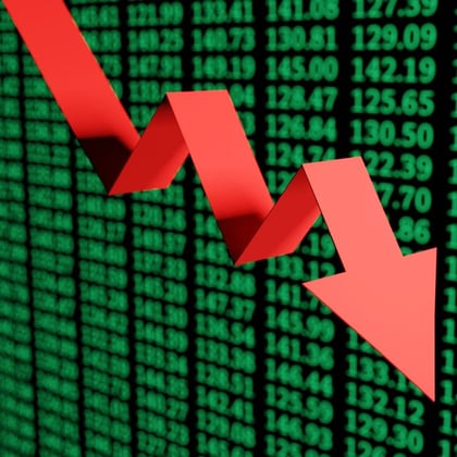 Red down arrow in front of a green screen of stock prices