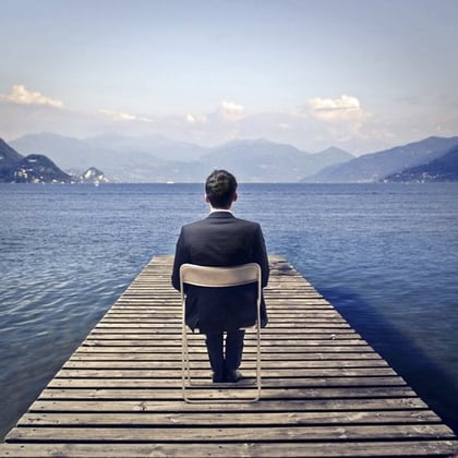 A man sitting on a pier on a beautiful lake. via DAMS