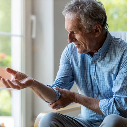 Senior man with arthritis rubbing his hand