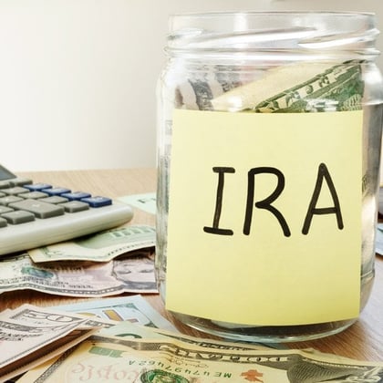 Roth IRA written on a label of the jar with money
