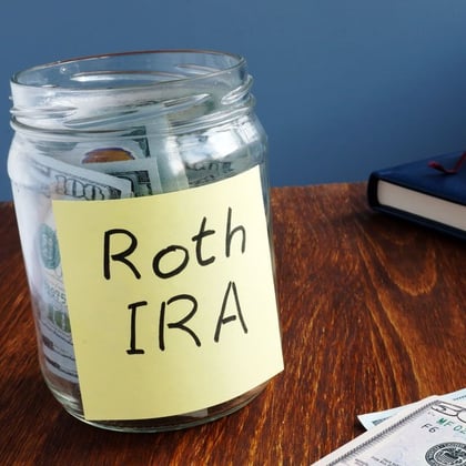 Roth IRA written on a label of the jar with money