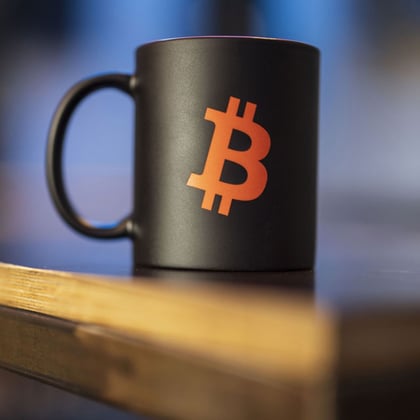 A Bitcoin logo on a mug.