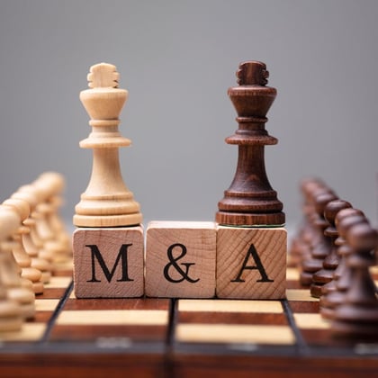 King chess pieces with M&A text on wooden blocks