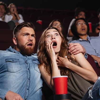 A couple in suspense at a movie theater.