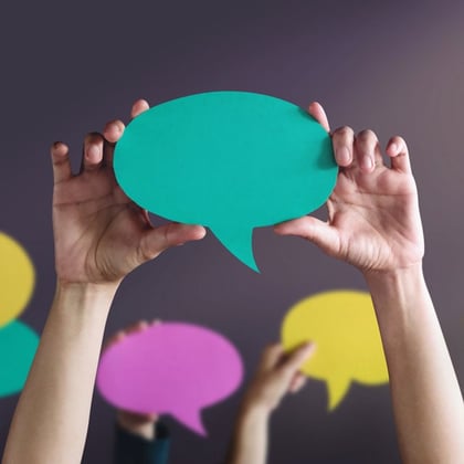 Group Hands Holding Speech Bubbles to symbolize social media posts and testimonials