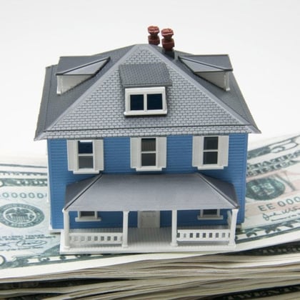 Figure of a house on a pile of money