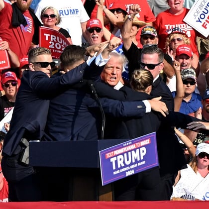 Former US President Donald Trump is surrounded by Secret Service agents during a campaign event at Butler Farm Show Inc. in Butler, Pennsylvania, US, on Saturday, July 13, 2024.