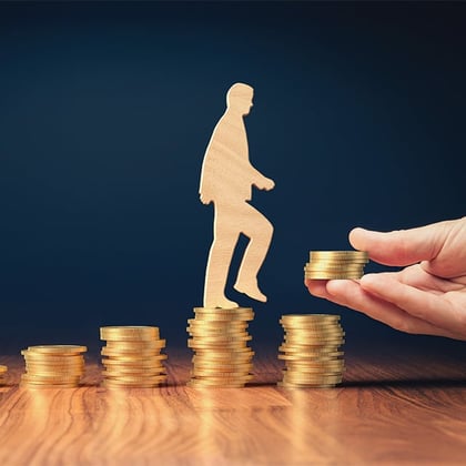 A man walking up a hill made of towers of coins