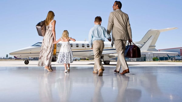 A wealthy family walks toward its jet